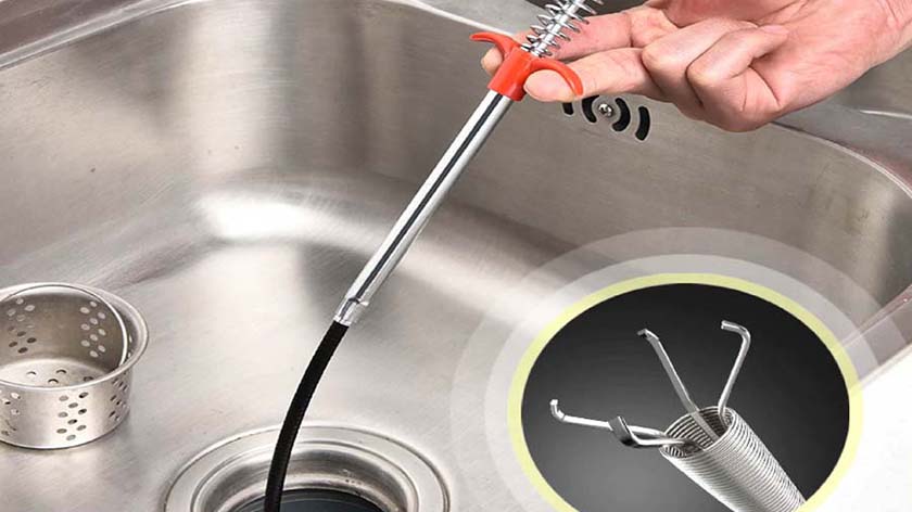 Dùng dây lò xo và móc sắt để thông tắc đường ống bồn rửa chén
