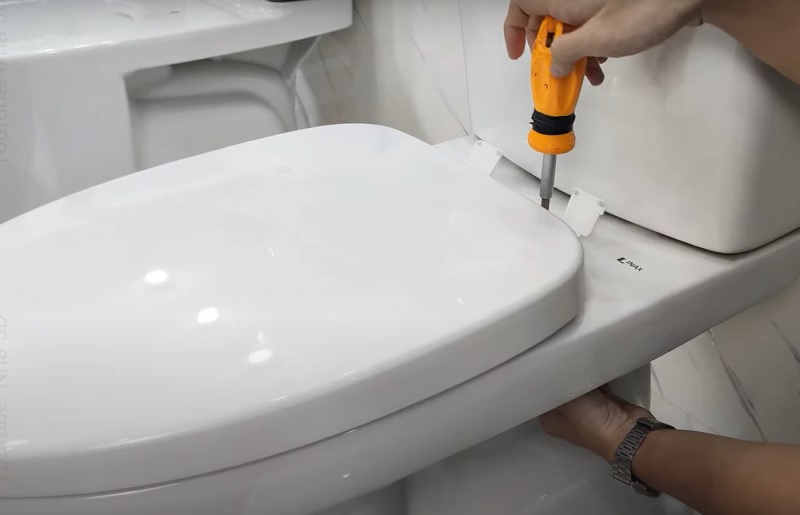 Bước 3: Linh kiện đi kèm nắp là bộ chốt nắp bồn cầu Inax đầy đủ. bạn chỉ cần căn chỉnh các lỗ của nắp bồn cầu mới cho vừa vặn với các lỗ bắt vít trên thân bồn cầu. Gắn vòng đệm inox vào lỗ rồi đặt vít vào lỗ của vòng đệm này.